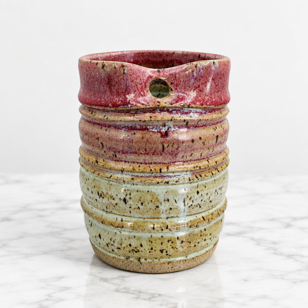 Handcrafted ceramic to-go cup perfect for your daily brew. Each cup is individually made with care, featuring a comfortable grip and generous 12 oz capacity. Glazed for durability and easy cleanin